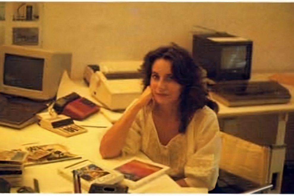 Interview with Laura Maestri Laura sitting at desk in 1986